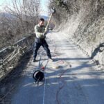 Geologo esegue indagine sismica su strada di montagna